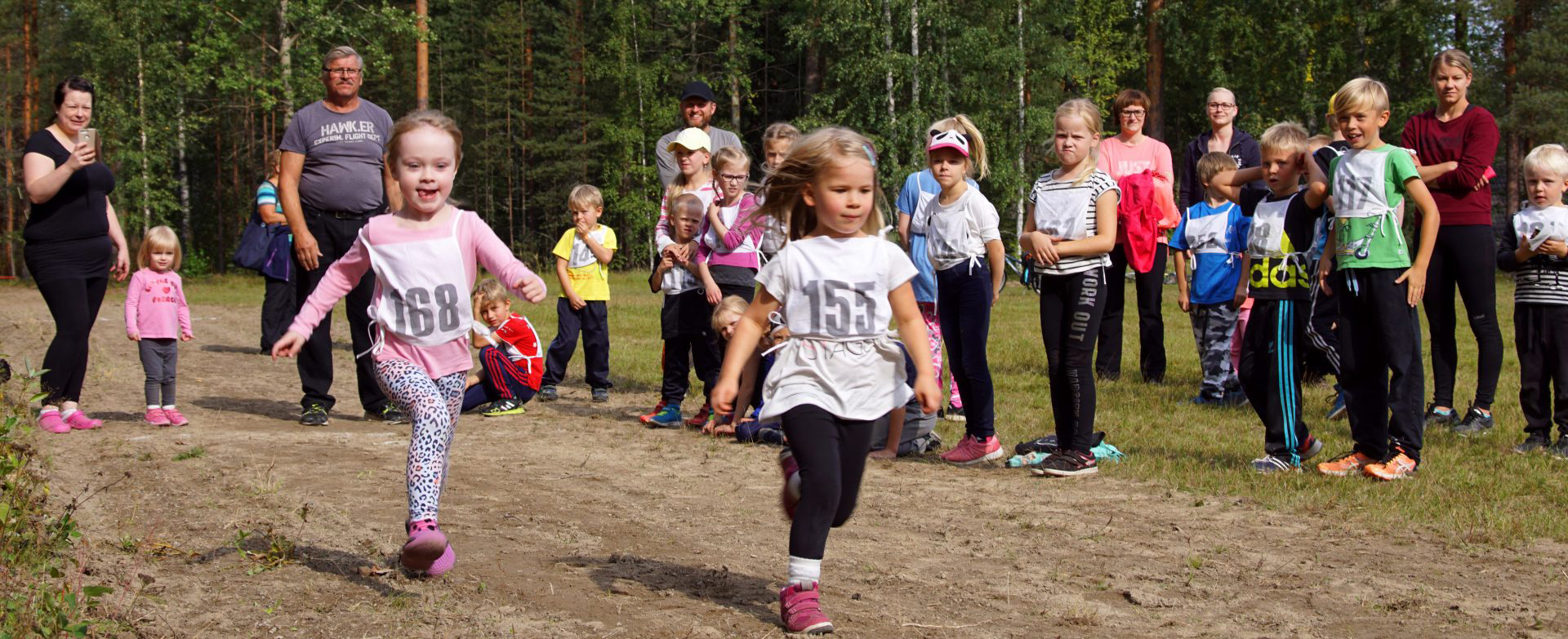 Lasten kisailua hiekkatiellä