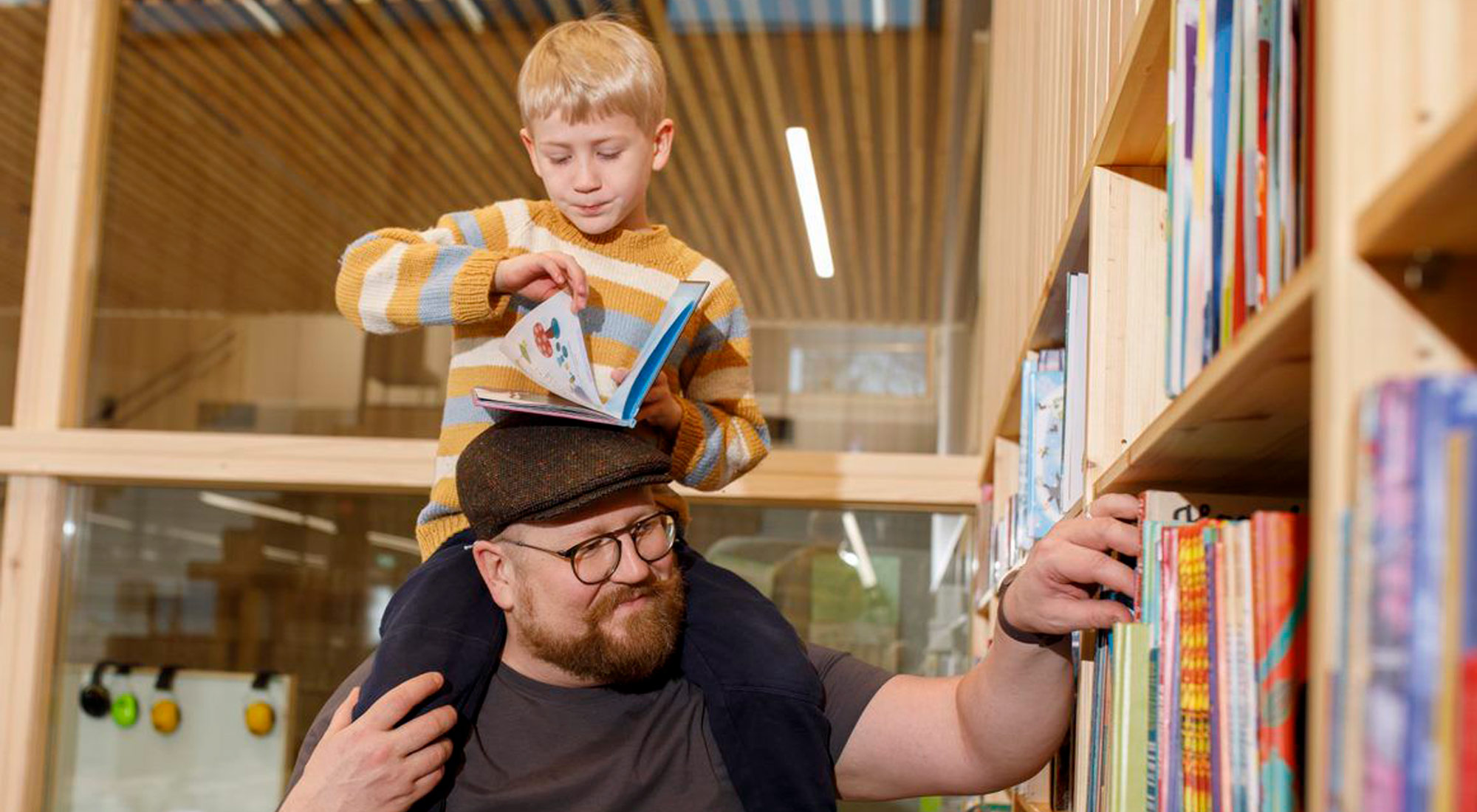 Isä ja lapsi tutkivat kirjahyllyä.