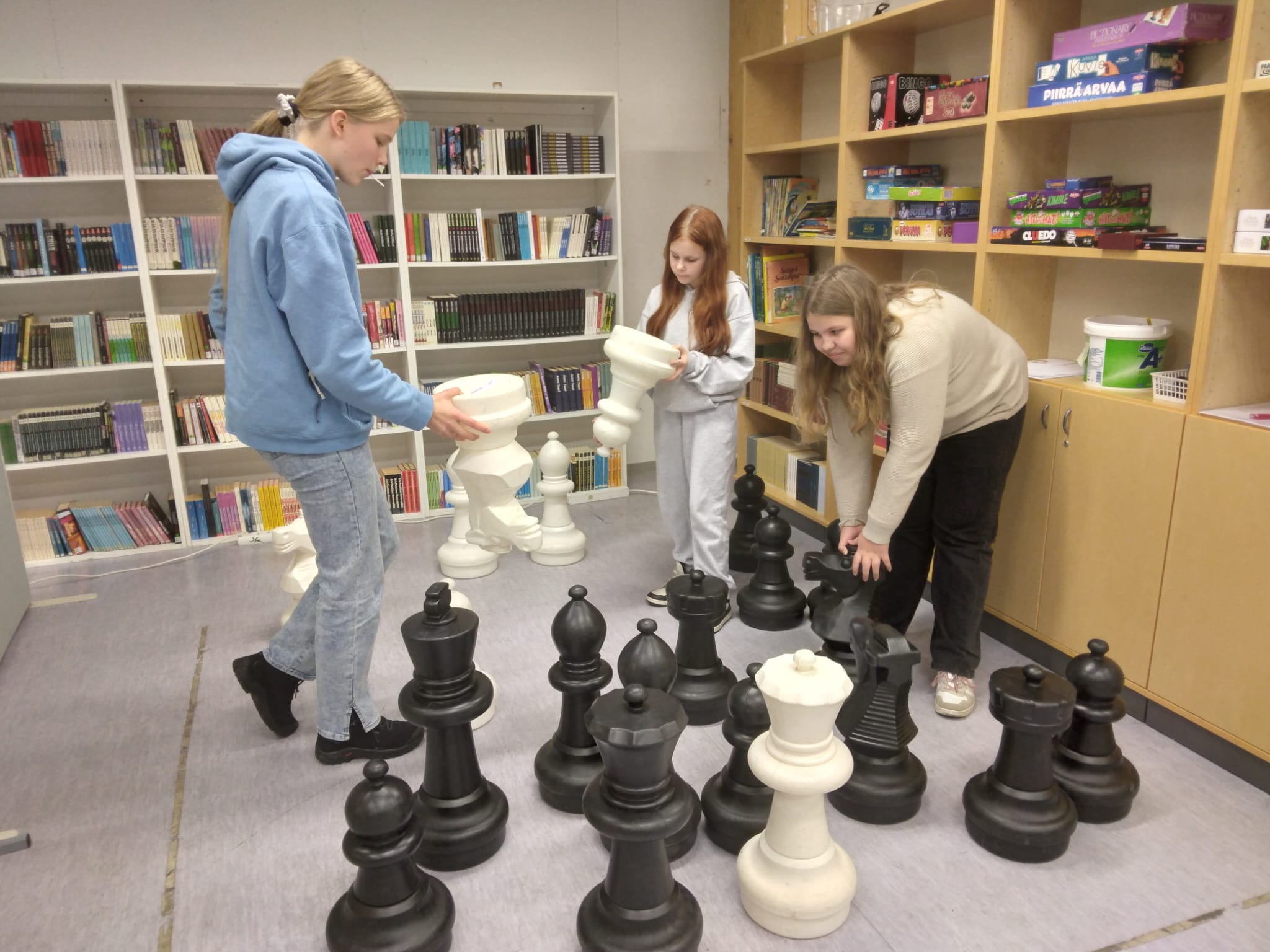 Oppilaat pelaavat shakkia isoilla nappuloilla.