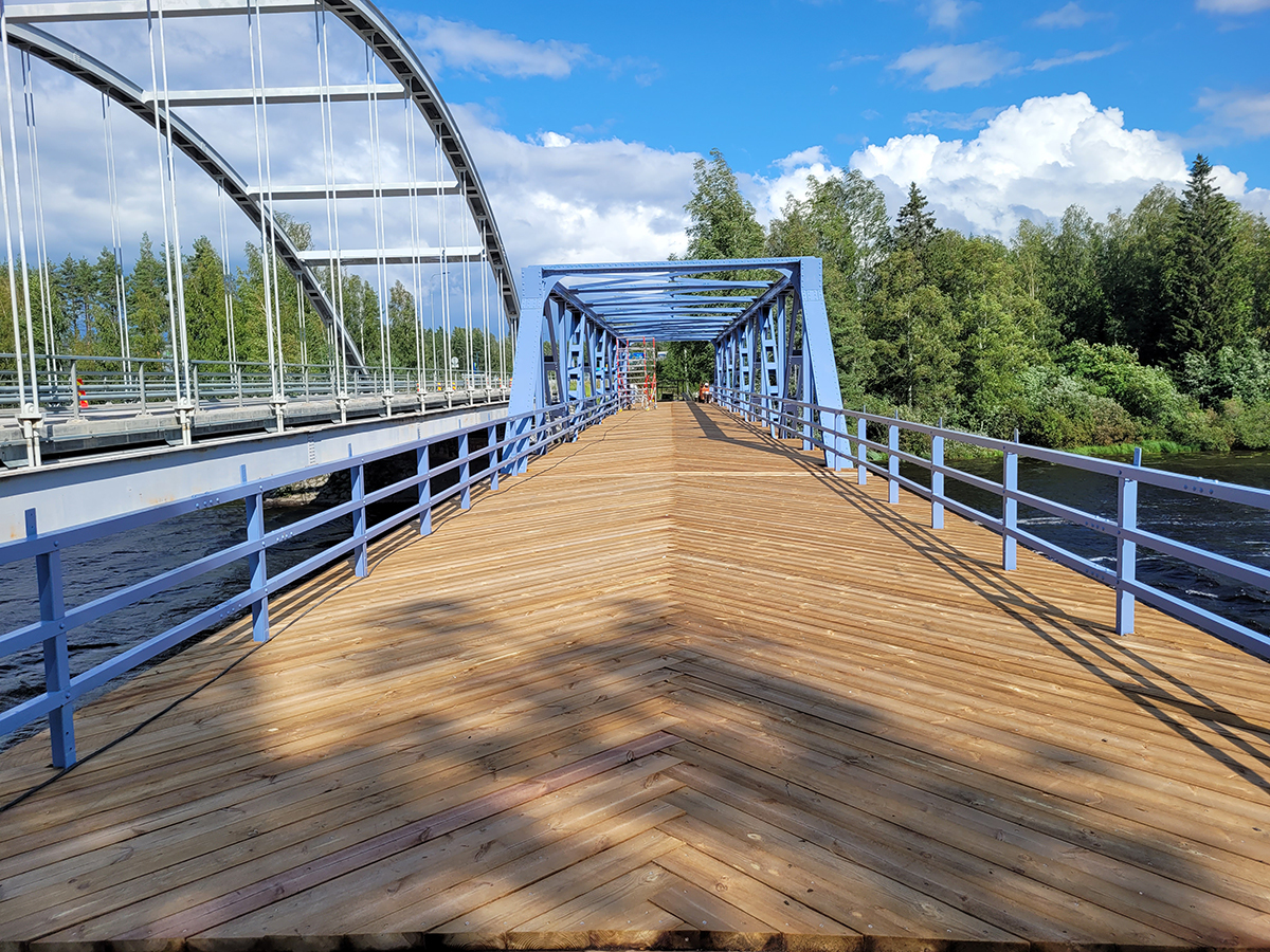 Silta, kaunis puukansi, järvi näkyy alla.